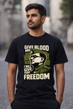 Man wearing a black t-shirt with a graphic and text on a blurred street background