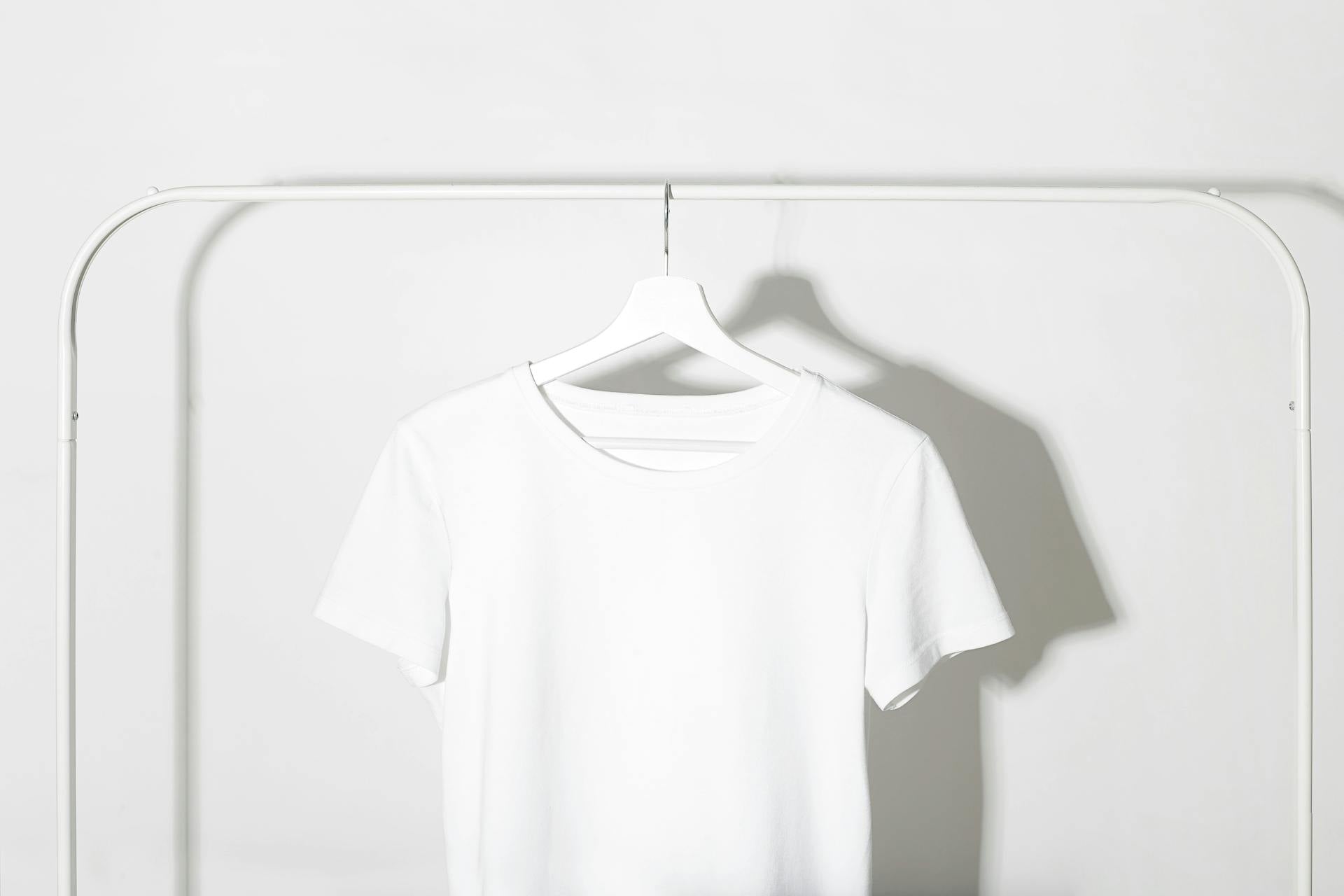 White t-shirt on a hanger against a white background